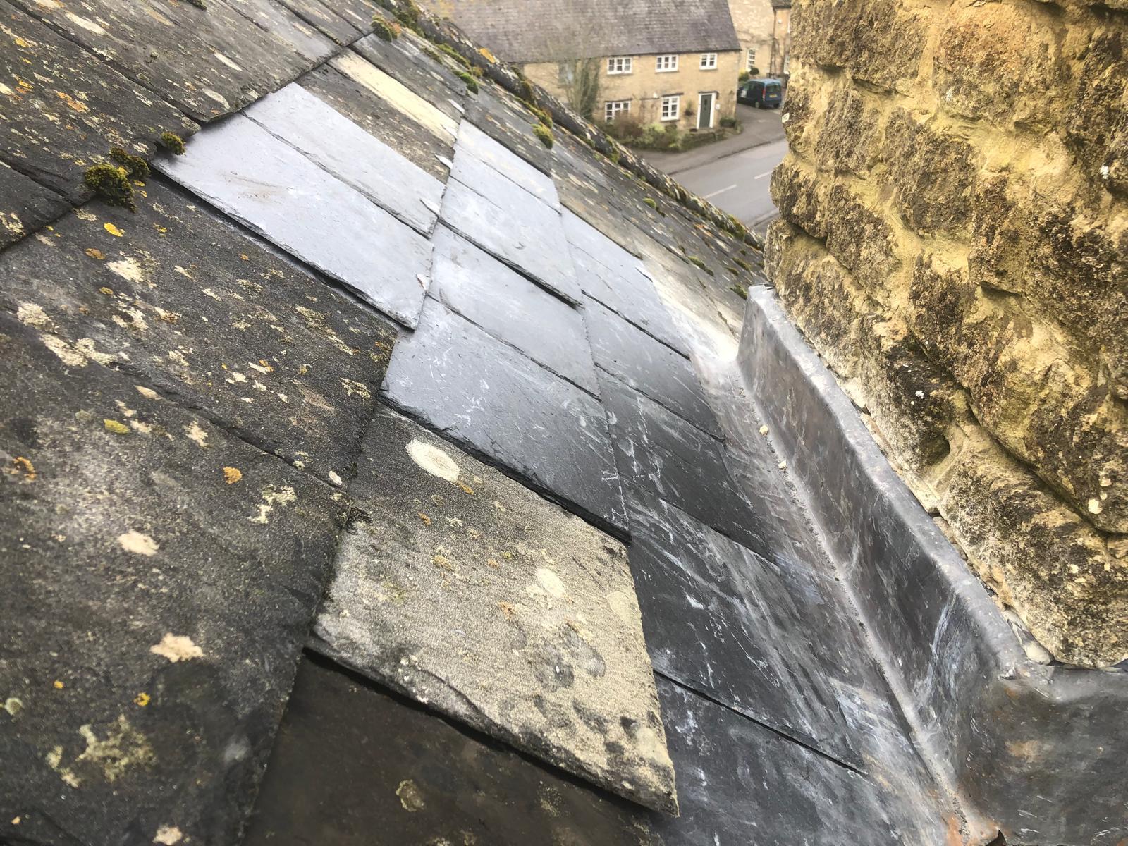 Completed lead flashing and reinstated slate covering beside a stone chimney