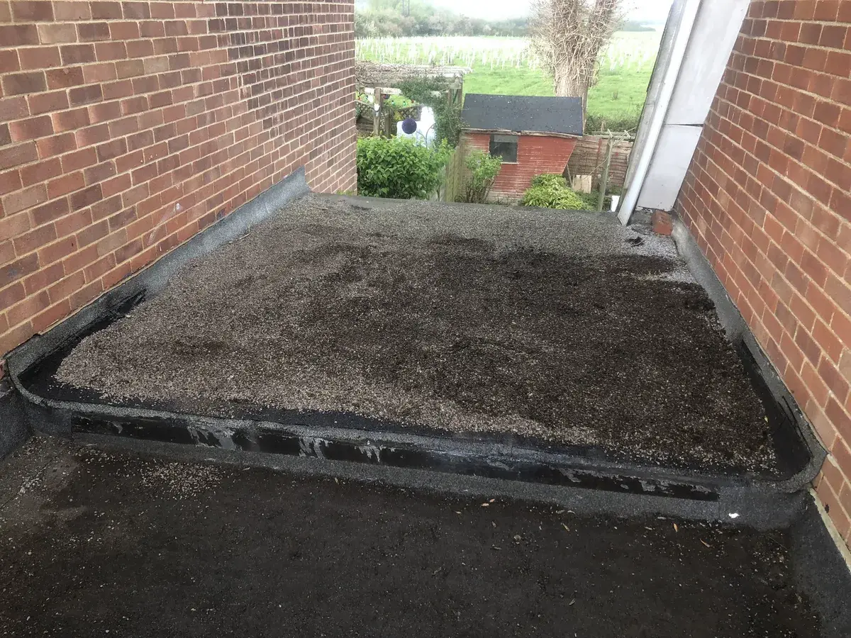 Stone reinstated over a completed temporary felt repair on a flat roof