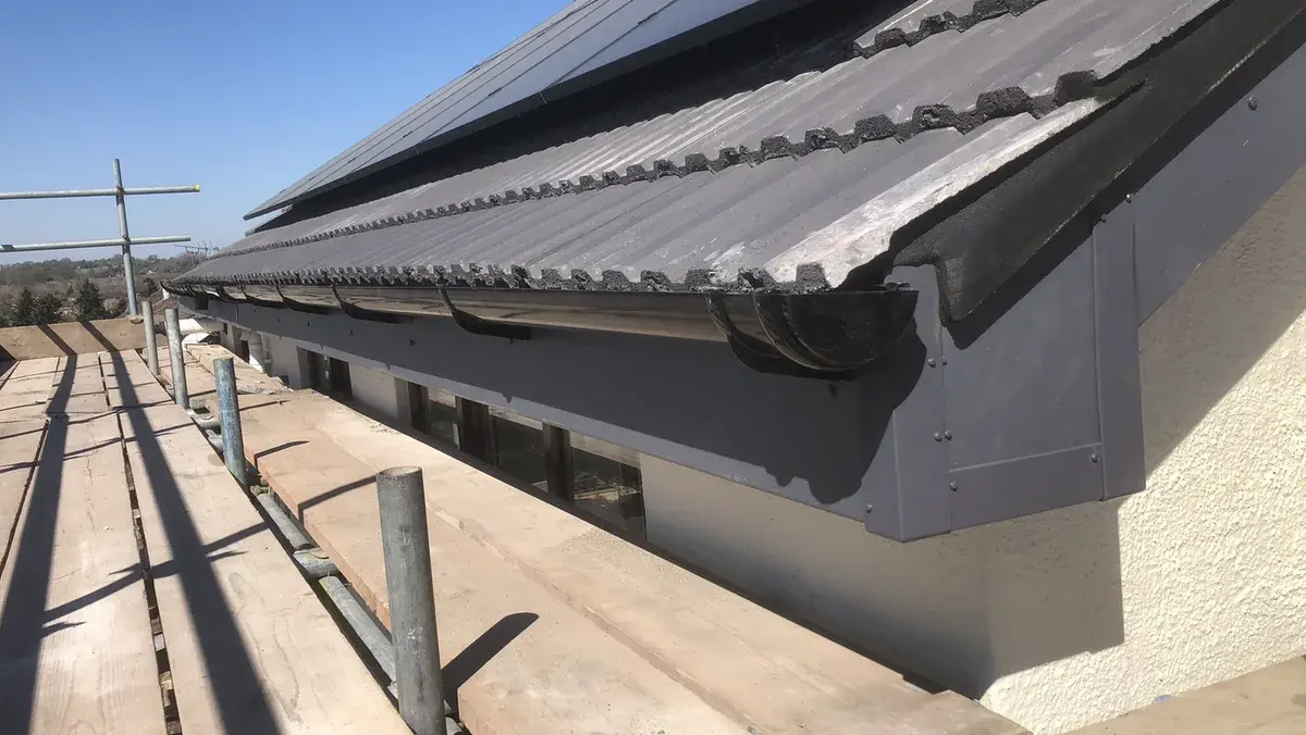 Completed black gutter and fascia beneath the renewed tiled roof