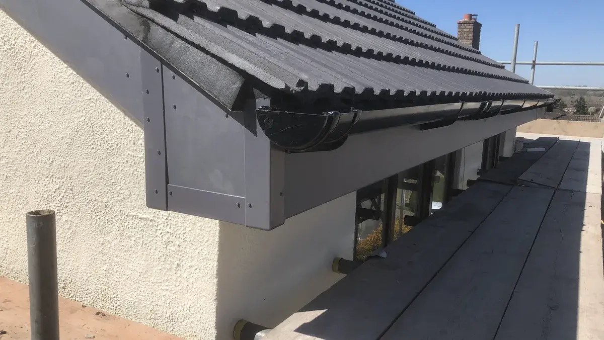 Completed black cement-boarded eaves with fascia and gutter