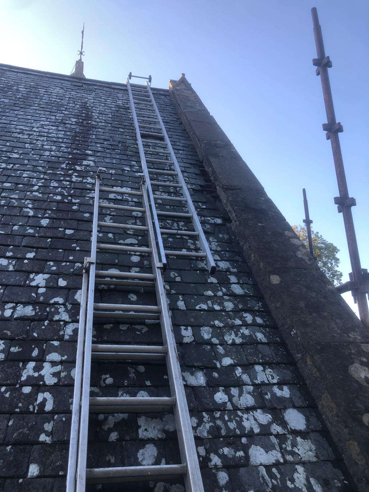 Slate roof and stone gable being accessed during Vallano Roofing repair work