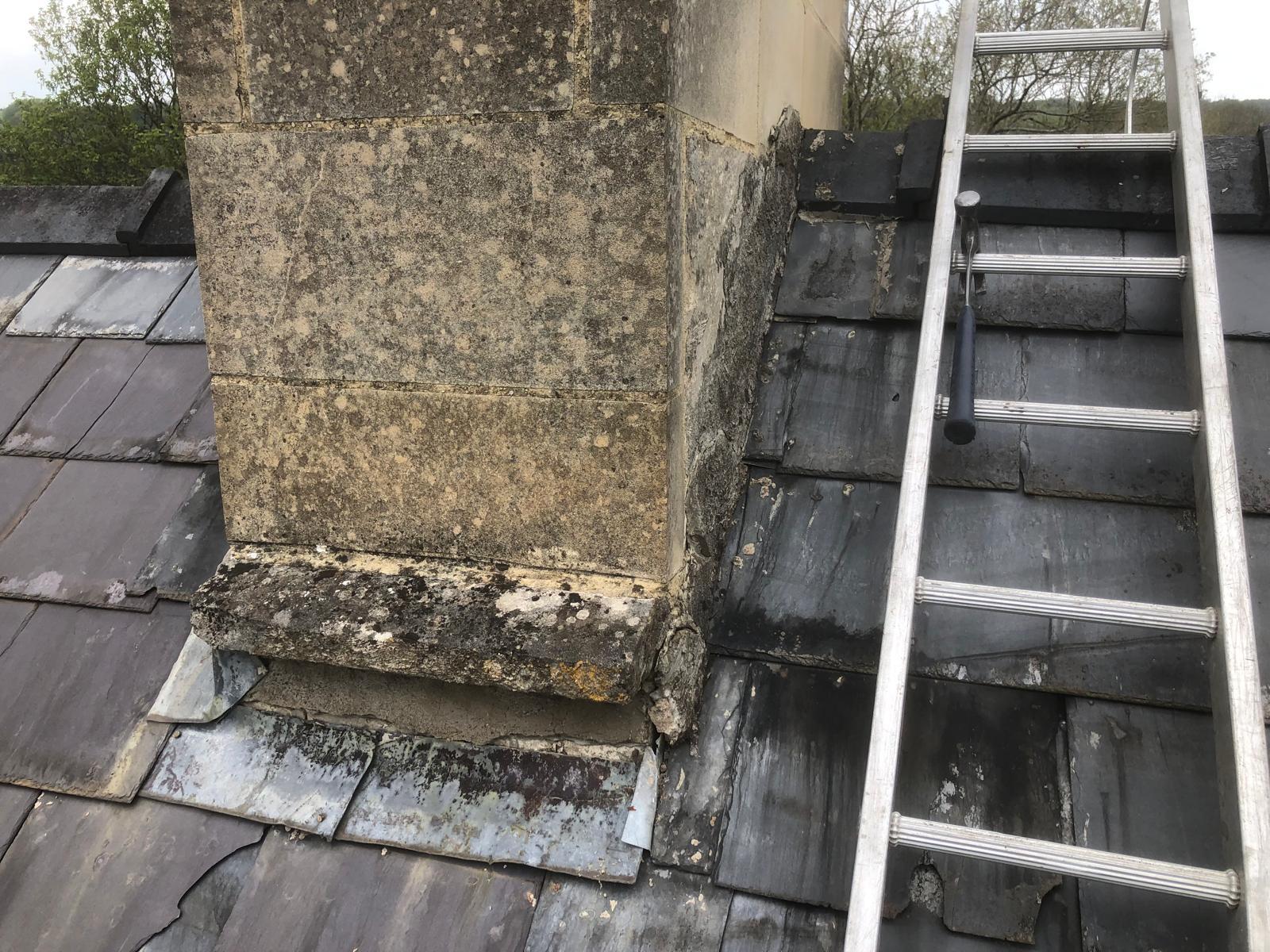 Damaged and missing slates around the base of a chimney